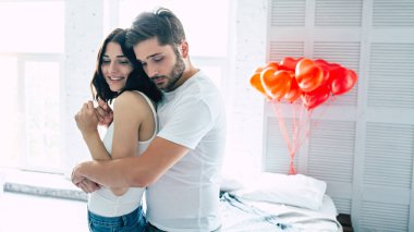 Genç heteroseksüel çift yatak odasında sarılma