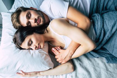 Genç heteroseksüel çift yatağa sarılma