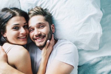 Genç heteroseksüel çift yatağa sarılma