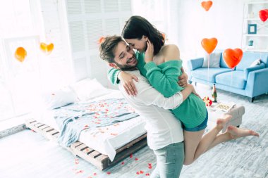 Genç adam holding kadın kollarında, yatak odası