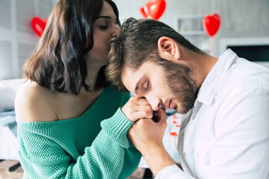 Katta yatak odasında genç çiftin birbirlerinin tutan eller