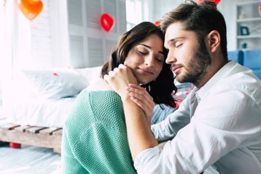 Genç çift katta yatak odasında sarılma