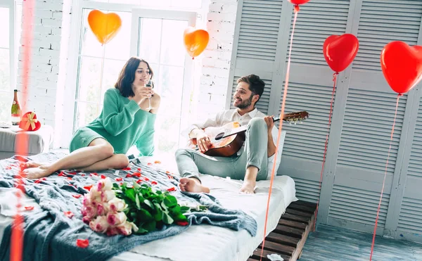 Genç çift yatakta, çiçekler ön planda odaklanın