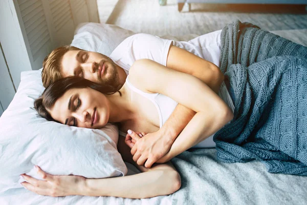 Genç heteroseksüel çift yatağa sarılma