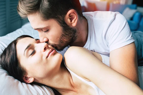 Genç heteroseksüel çift yatağa sarılma