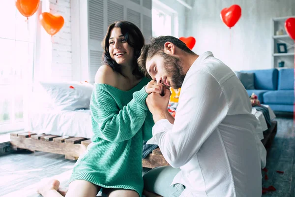 Katta yatak odasında genç çiftin birbirlerinin tutan eller