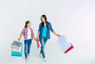 Anne ve kızı beyaz arka plan üzerinde alışveriş torbaları ile konsept alışveriş