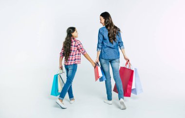 Anne ve kızı beyaz arka plan üzerinde alışveriş torbaları ile konsept alışveriş