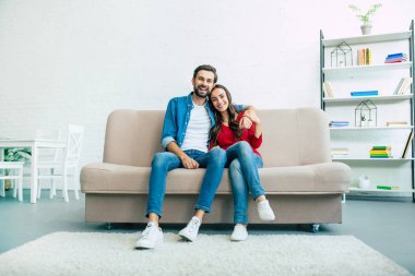 Işık oturma odasında kanepede oturan genç mutlu aile