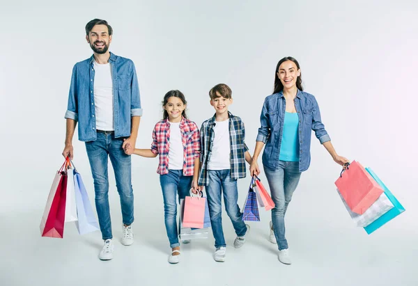 Beyaz arka planda, alışveriş torbaları ile genç beyaz aile kavramı alışveriş 