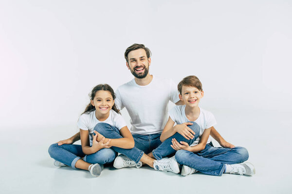 Young father posing with children on white background