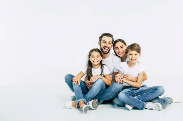 Group portrait of young caucasian family with son and daughter on white background