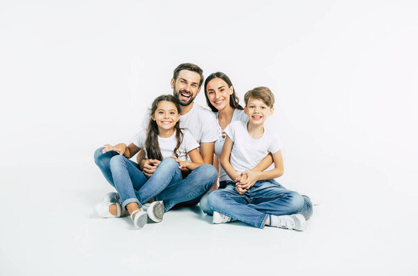 Group portrait of young caucasian family with son and daughter on white background
