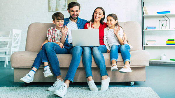 Young family using laptop and spending time at home