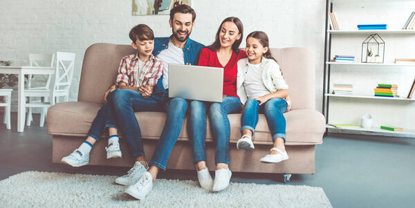 Young family using laptop and spending time at home