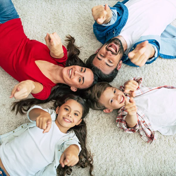 幸福的家庭躺在地板上圆的顶部视图 — 图库照片