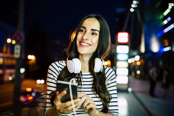 Młoda Kobieta Uśmiechający Się Słuchanie Muzyki Słuchawkach Smartphone — Zdjęcie stockowe
