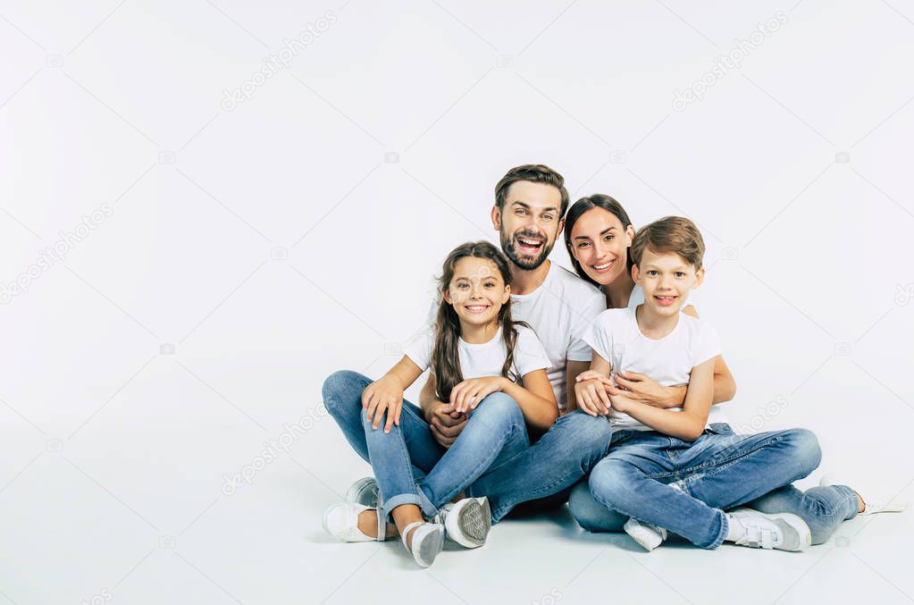 Group portrait of young caucasian family with son and daughter on white background