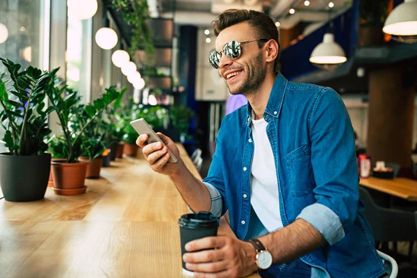 Młody Człowiek Siedząc Kawiarni Przy Użyciu Smartfona — Zdjęcie stockowe