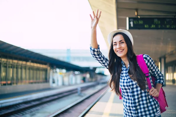 駅で列車を待っている若いカジュアルな女性 — ストック写真