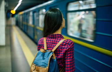 Arkadan görünüşü metro tren bekleyen genç