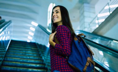 Yeraltı yürüyen merdiven üzerinde duran genç kadın 