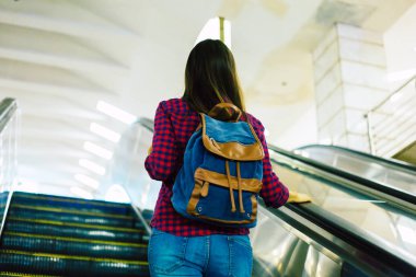 Yeraltı yürüyen merdiven üzerinde duran genç kadın 