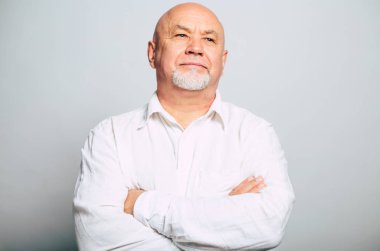 gri arka plan üzerinde poz çapraz kollu beyaz gömlekli sakallı yakışıklı portresi 