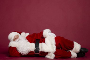 Noel Baba kostüm kırmızı zemin üzerine yalan adam portresi Noel ve yeni yıl kavramı 