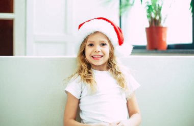 Kameraya poz santa şapkalı gülümseyen kız