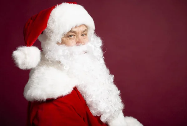 Boční Pohled Člověka Kostýmu Santa Clause Zatímco Pózuje Červeném Pozadí — Stock fotografie