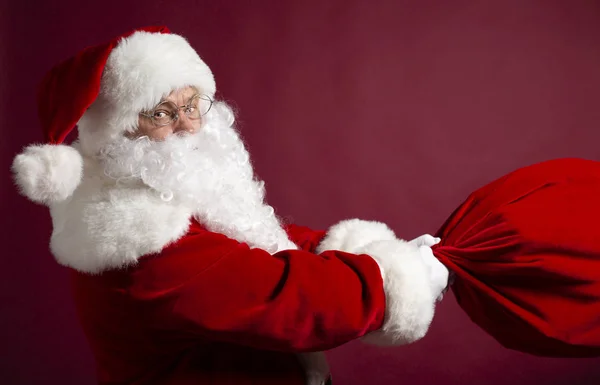 Portrét Muže Kostýmu Santa Clause Drží Dárkový Pytel Červeném Pozadí — Stock fotografie
