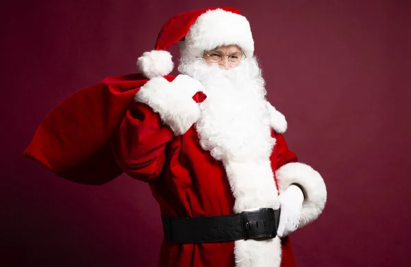 Portrét Muže Kostýmu Santa Clause Pytlem Dárky Zádech Pózuje Červeném — Stock fotografie