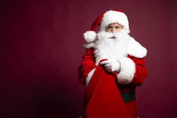 Portrét Muže Kostýmu Santa Clause Drží Dárkový Pytel Červeném Pozadí — Stock fotografie