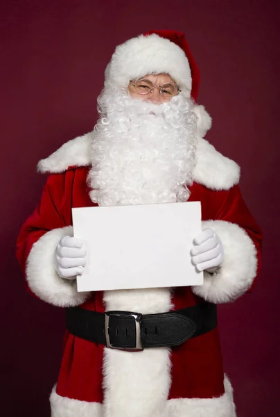 男子肖像在圣诞老人条款服装持有白色空白横幅在红色背景 圣诞节和新年概念 — 图库照片