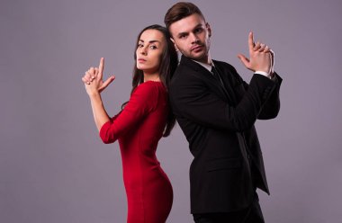 Takım elbise ve elbise güzel şık ve zarif çift arka arkaya ayaktadır, eğlenceli ve poz izole stüdyo. Tatiller ve olaylar. St Valentine's day. Sevgililer günü