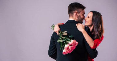 Mutlu çift gri arka plan üzerinde poz