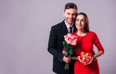 Mutlu çift gri arka plan üzerinde poz