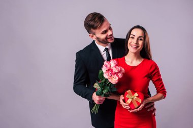 Mutlu çift gri arka plan üzerinde poz