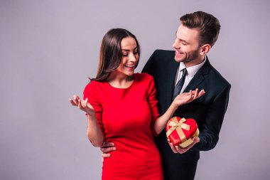 Mutlu çift gri arka plan üzerinde poz