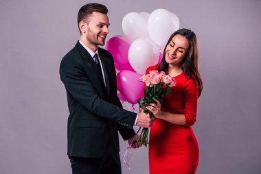 Mutlu çift gri arka plan üzerinde poz