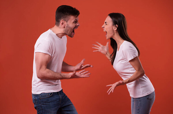 Side view photo of young angry and shouting couple in white t-shirts
