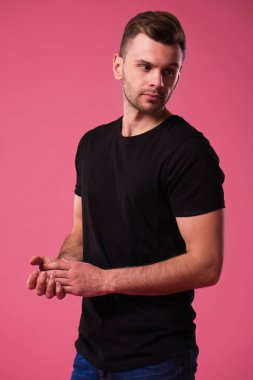 Siyah t-shirt, pembe arka plan poz güzel şık kendinden emin ve ciddi adam