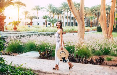 Hayhay! Üstün kız çokluğu ile birlikte deri ayakkabı, camel şapka ve foxy çanta siyah ve beyaz kıyafeti giymiş hassas bitkiler üzerinde geçiyor.