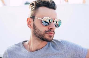 Derin su. Siyah saçlı ve pürüzsüz cilt gri t-shirt ve turkuaz renkli deniz suyu ve bir tatil kruvazör bir parçası bir yansıması ile güneş gözlüğü takan yakışıklı çocuk.