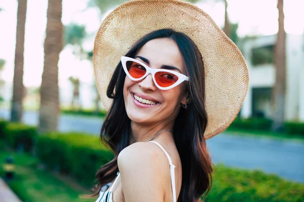 A run into the gladness. Prodigious woman with naturally glowing skin, brown hair and brilliant smile all over her face is effusing happiness in front of beauty of the nature.