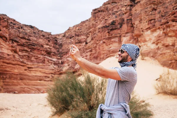 クーフィーヤと砂漠のシーンで Selfie を取ってサングラスを身に着けている旅行者 — ストック写真