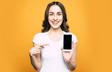 Bir geek bak. Gülen kız ile bir cep telefonu onun elinde sadece bir şey ne mutlu ona doğru bu telefona yapılan dikkat onun parmak ile işaret ediyor.