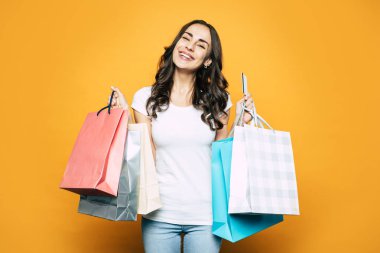Düşene alışveriş. Alışveriş torbaları farklı renklerde onun elinde olan bir kredi kartı ile ödenen onun satın alma ile tam bir sürü genç kız.