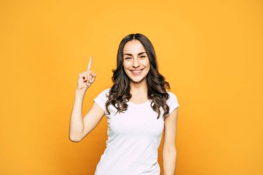 Not istiyorum. Şu spice turuncu arka plan yanında duran güzel genç kız göz alıcı ile uzun kıvırcık kumral beyaz gülümseme gökyüzü parmak işaret A.